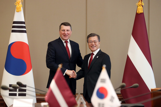 Latvia's then-President Raimonds Vejonis, left, shakes hands with President Moon Jae-in at the Blue House on Feb. 13, 2018, during their summit meeting. [BLUE HOUSE]