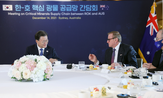 President Moon Jae-in, left, discuss with Simon Crean, Australia-Korea Business Council chairman, during a meeting on critical mineral supply chain at a hotel in Sydney on Tuesday. [YONHAP]