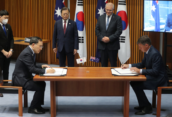 Korean Minister Moon Sung-wook and Australian Minister for Industry, Energy and Emission Reduction Angus Taylor signs an agreement between the two countries in cooperating on carbon neutrality during a ceremony held at the Parliament House in Canberra on Monday. the two ministers held a seperate meeting on Tuesday in Sydney. [YONHAP] 