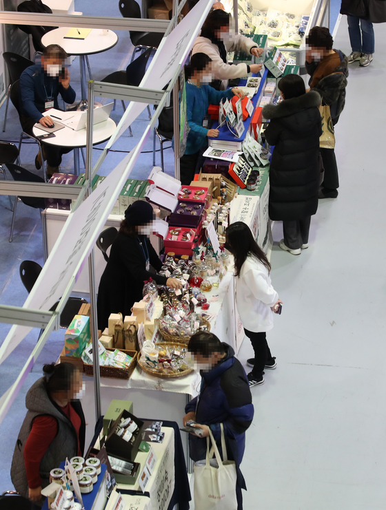 Visitors look at holiday gifts sold at the 2021 Festive Gift Fair held in Coex, southern Seoul, on Wednesday, ahead of the upcoming Lunar New Year holiday that falls on Feb. 1 next year. A variety of fruit, ginseng and liquor products are sold at the event, which runs through Saturday. [YONHAP] 