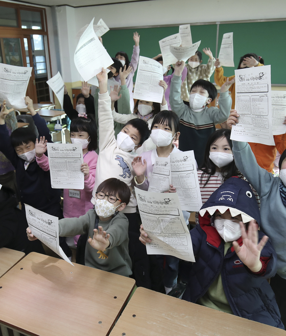 First graders of Pyeongsan Elementary School in Ulsan show their excitement on Wednesday as their two-month winter vacation starts. [NEWS1]
