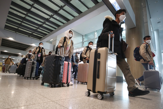 Travelers enter Incheon International Airport on Tuesday amid mounting concerns over the Omicron variant. [YONHAP]