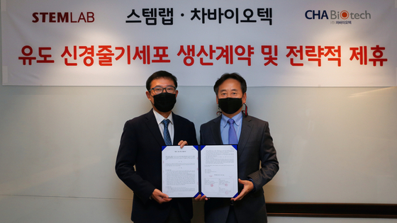 Oh Sang-hoon, right, CEO of CHA Biotech, and Choi Jong-sung, CEO of StemLab, pose for a photo after signing a contract manufacturing organization deal. [CHA BIOTECH]