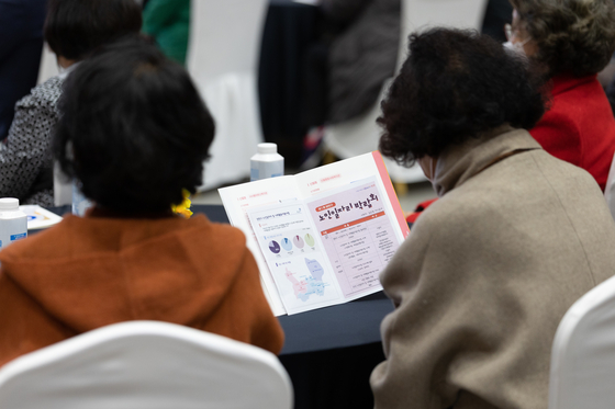 Senior citizens read pamphlets at a job fair held Yangcheon District, western Seoul, on Nov. 9. [NEWS1]