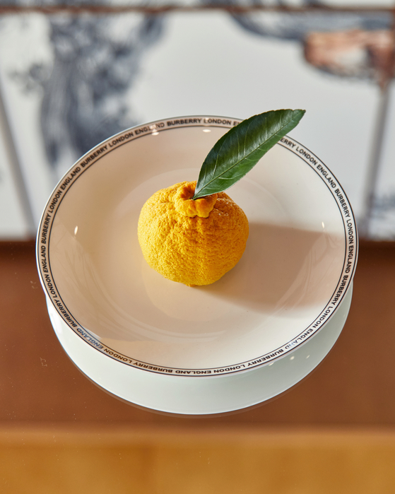A citrus sorbet shaped like Jeju's well-known hallabong, a type of orange, served during Buberry's pop-up cafe Thomas's [BURBERRY]