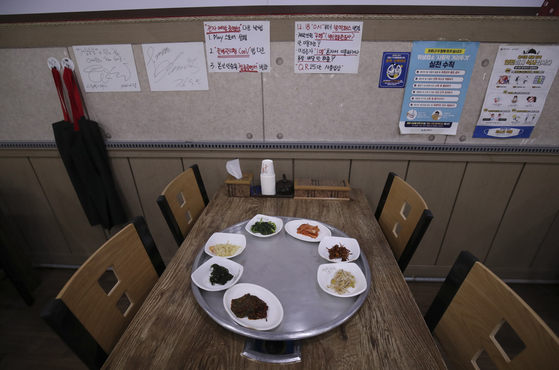 Signs explaining that gatherings will be limited to four vaccinated people starting Saturday are posted at a restaurant in Nam District, Ulsan, Thursday. The government announced earlier that day renewed social distancing measures limiting private gatherings and implementing nighttime curfews on restaurants and other businesses set to for the next two weeks until Jan. 2. [NEWS1]