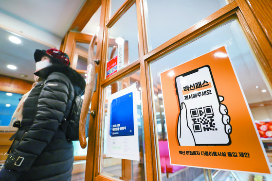  A guide on how to use the digital vaccine pass system is posted on the window of a restaurant in Seoul on Dec. 13, the day the system was switched on. [YONHAP]