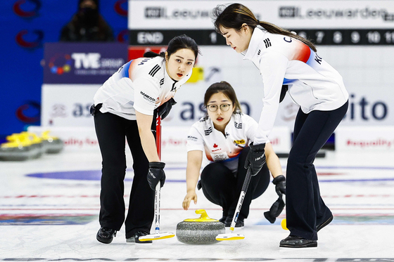 From left, Kim Kyeong-ae, Kim Seon-yeong and Kim Cho-hi compete on Saturday at the curling qualifying tournament for the 2022 Beijing Winter Olympics in the Elfstedenhal in Leeuwarden, the Netherlands. [AFP/YONHAP]