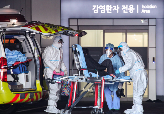A Covid-19 patient arriving in an ambulance from Incheon is being transferred to Seoul Medical Center in Jungnang District, eastern Seoul, on Sunday, as the country struggles with a tight supply of hospital beds. [YONHAP]