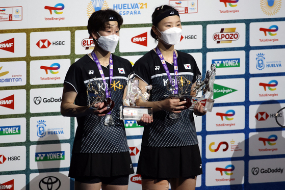 Silver medalist Lee So-hee, walked away.  and Shin Seung-chan pose on the podium after the BWF World Championships women's doubles final badminton match in Huelva, Spain, on Sunday. [AFP/YONHAP]