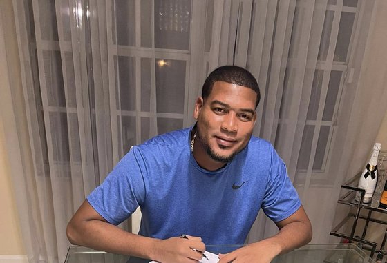 Ivan Nova is photographed signing his contract in a photo released by the SSG Landers. [SSG LANDERS]