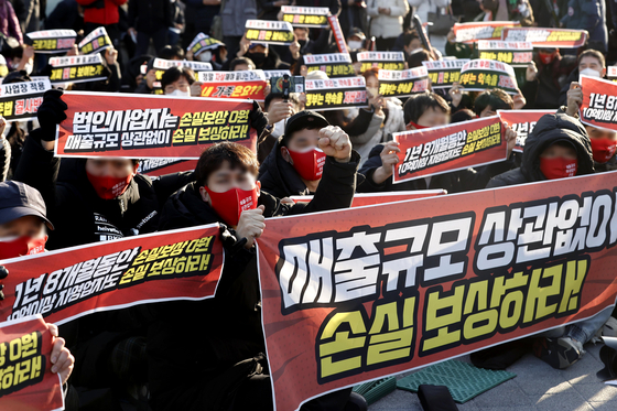 Business owners and self-employed people in Korea rally in Gwanghwamun square in central Seoul on Wednesday to protest the government's reinstatement of restrictions on business operation hours and the expansion of the vaccine pass system earlier this month. [YONHAP]