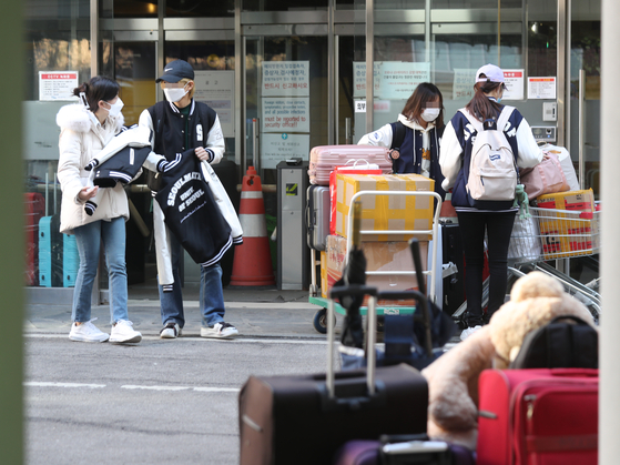 College students at the University of Seoul move out of the dormitory on Wednesday as the space will be offered as a treatment facility for Covid-19 patients with minor symptoms. [YONHAP]