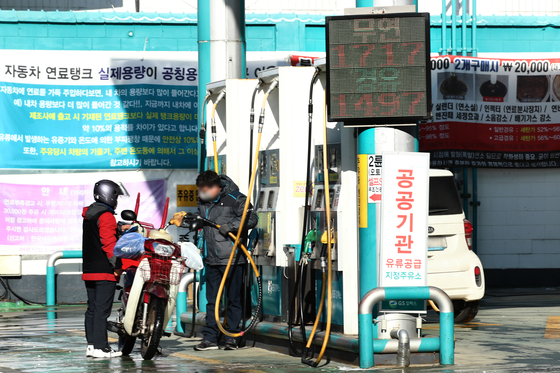 A motorcyclist fills up fuel at a gas station in Seoul in December. While oil prices have recently been stablizing the government announced of releasing its strategic reserve for 2022 on Thursday. [YONHAP]
