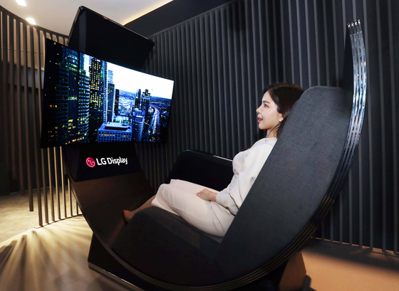 A model tries out LG Display's Media Chair that combines a recliner and a curved OLED display. [LG DISPLAY]