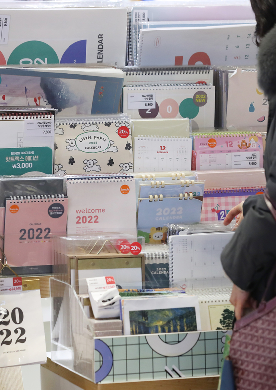 Next year's calendars are displayed at stationary store Hot Tracks, located inside Kyobo Bookstore in Gwanghwamun, central Seoul, on Monday. With only few days left this year, people have been purchasing calendars and diaries for 2022. [YONHAP] 