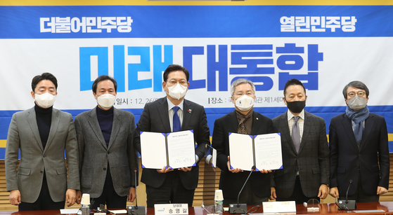 Center left, the ruling Democratic Party chairman Song Young-gil, and center right, the minor liberal Openminjoo Party chairman Choe Kang-wook, hold up the agreement they signed Sunday at the National Assembly in western Seoul on merging the two parties ahead of the March presidential election. [NEWS1]