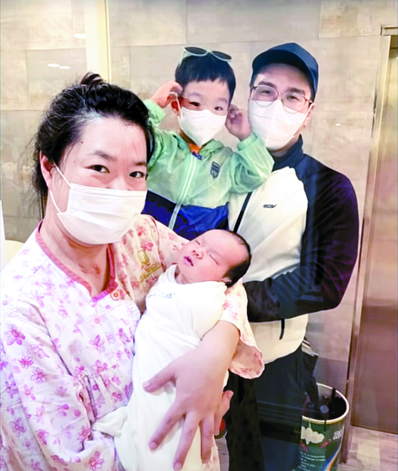 Kim Mi-na holds her newborn baby in September with her family. [KIM MI-NA]