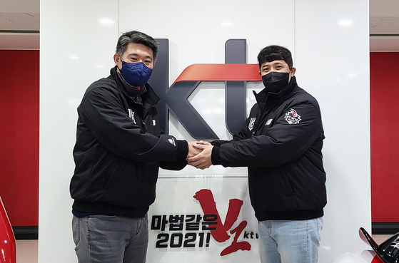 KT Wiz infielder Hwang Jae-gyu, right, shakes hands with the club's general manager, Lee Soong-yong, on Monday after signing a new four-year contract. [YONHAP]