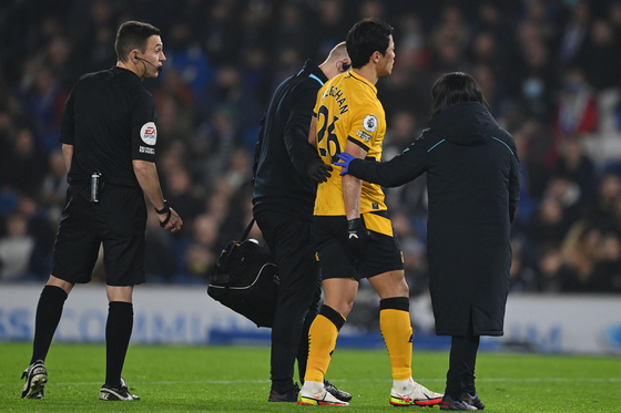 Wolverhampton Wanderers' striker Hwang Hee-chan is helped out of the pitch after picking up an injury during a Premier League match against Brighton at the American Express Community Stadium in Brighton, England, on Dec.15. [AFP/YONHAP] 