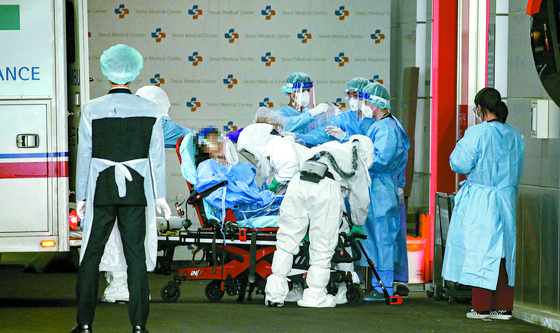  Medical staff are hurriedly moving a critically-ill Covid-19 patient to an emergency room at Seoul Medical Center, Dec. 14.  [YONHAP]