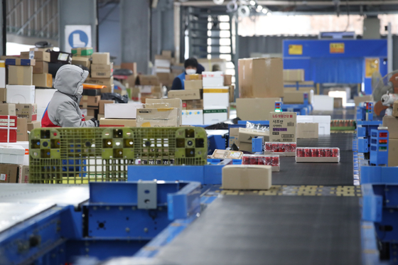 A delivery worker sorts packages at a CJ Logistics warehouse in Gwangju, Gyeonggi, on Tuesday. [YONHAP]