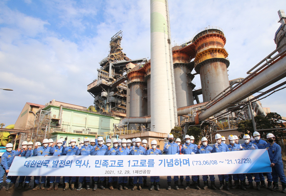 Employees pose for a photo in front of Posco’s Pohang No. 1 blast furnace in Pohang, North Gyeongsang, on Wednesday. The company on Wednesday retired the blast furnace after operating it for 48 years and six months. [POSCO]