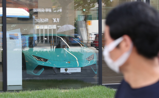 A passerby walks in front of an Automobili Lamborghini store in downtown Seoul in August. [NEWS1] 