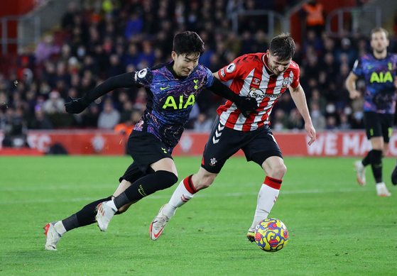 Tottenham Hotspur's Son Heung-min, left, plays the ball against Southampton's Romain Perraud at St Mary's Stadium in Southampton, England, on Tuesday. [REUTERS/YONHAP]