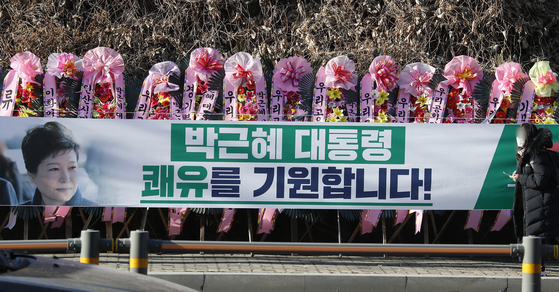 Floral arrangements and banners welcoming the release of former President Park Geun-hye decorate a sidewalk outside Samsung Medical Center in Gangnam District, southern Seoul on Thursday. [NEWS1]