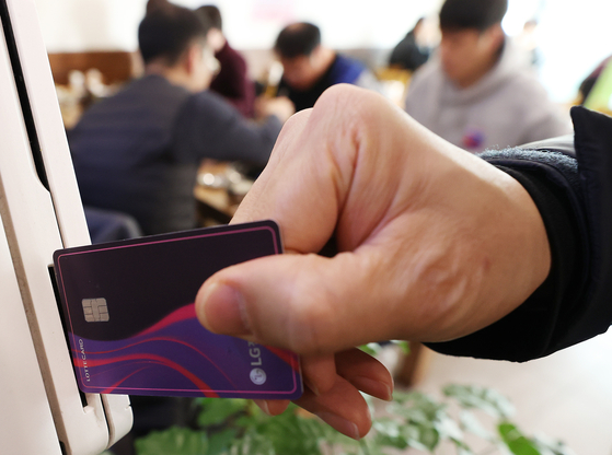 A credit card being swiped at a restaurant in Seoul in December. Despite relaxed social distancing regulation, concerns over the ongoing pandemic in November affected spending. [YONHAP] 