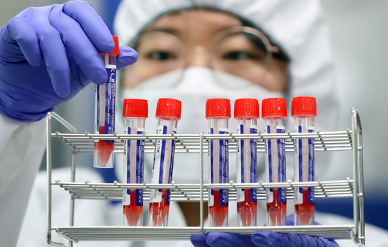 A researcher at the Sejong Institute for Health and Environment in Sejong City examines refrigerated Covid-19 samples Thursday after Korea rolled out new PCR tests that can detect the Omicron variant within four hours to be used by local governments nationwide. [NEWS1]