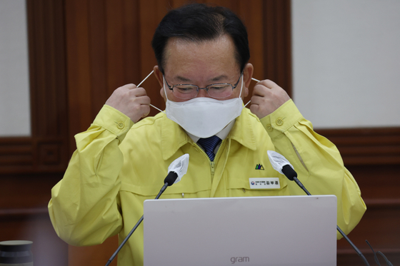 Prime Minister Kim Boo-kyum removes his mask before speaking at a meeting of the Central Disaster Management Headquarters at the Seoul government complex in Jongno District, central Seoul on Friday. [YONHAP]