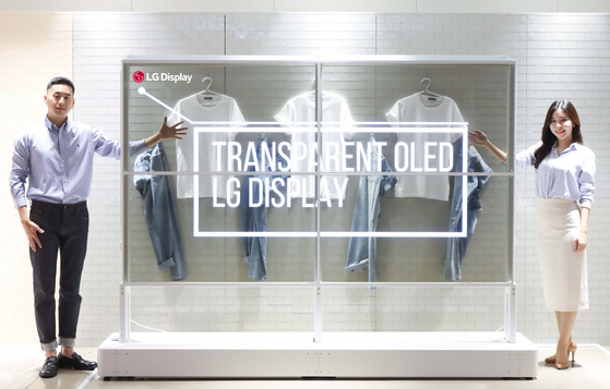 The models promote a transparent OLED exhibition window developed by LG Display. [LG DISPLAY]