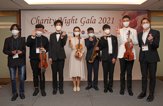 Winners of the 5th Great Music Festival, from left, Kang Sang-su, Ji Yeon-jun, Lee Yu-bin, Choi Yun-jeong, Lim Eun-gyu, Lee Kang-hyeon and Ryu Jong-won and jazz pianist and TV personality Daniel Jakob Lindemann celebrate the end of year with a concert at the Charity Night Gala 2021 at Lotte Hotel Seoul on Tuesday. [PARK SANG-MOON]