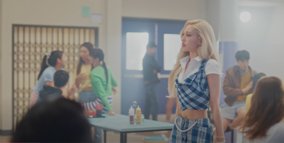 One of the key elements in the ″high teen″ look is school uniforms, stylized in retro plaid patterns and bright, vivid colors. The above screen capture shows singer Jeon Somi in her music video for ″Dumb Dumb″ (2021). [SCREEN CAPTURE]