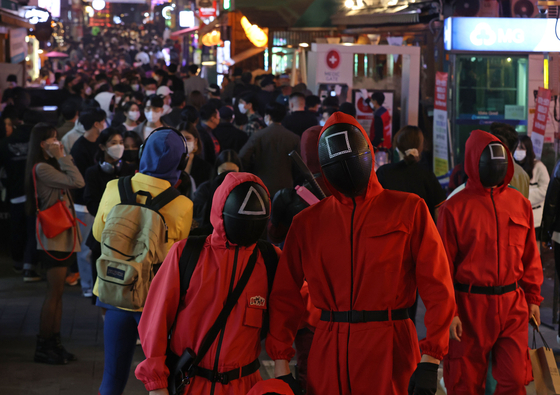 People dress up as characters from Netflix popular series "Squid Game" and celebrate Halloween in Itaewon, central Seoul, on Friday. [YONHAP]