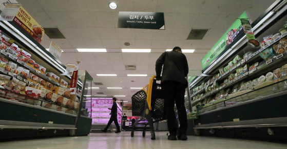 A shopper checks out groceries at a discount mart in Seoul. [NEWS1]