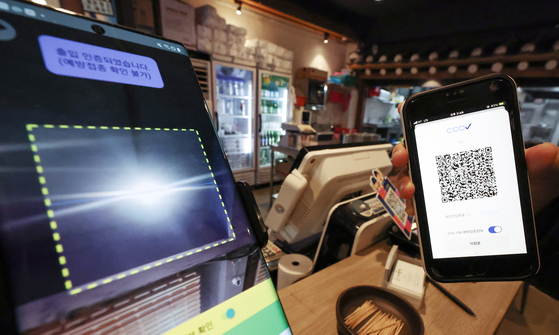 An unvaccinated person scan their QR code at a restaurant in Seoul on Tuesday. [YONHAP]