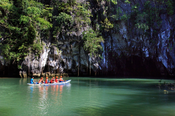 Travelers sit on a small boat on the Puerto Princesa Subterranean River National Park, where the world's longest ″underground river″ is located. [PHILIPPINE DEPARTMENT OF TOURISM IN KOREA]
