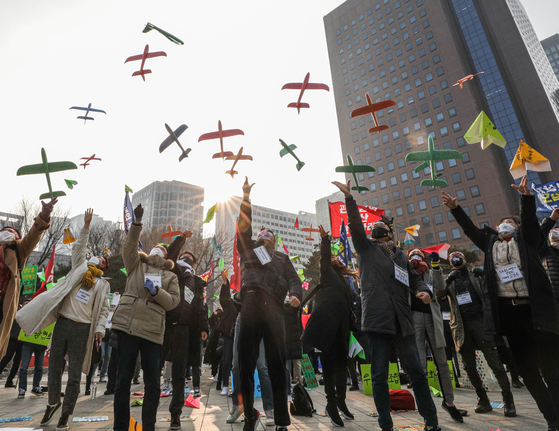 Near the Bosingak Belfry in Jongno District, central Seoul, on Sunday, tourism industry workers stage a rally to express their frustration against longer-than-expected travel restrictions caused by the Covid-19 pandemic. They flew airplane models to push for freer international travel. [NEWS1]