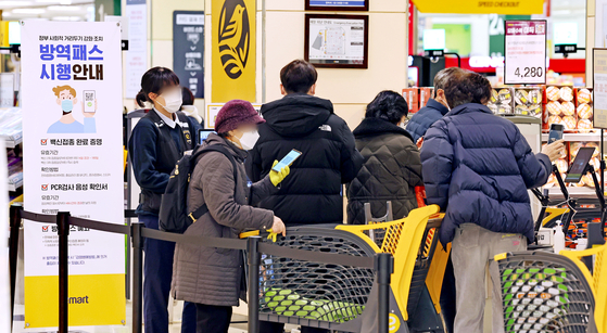 Shoppers flash QR code to prove their vaccination status upon entry to an Emart in Seoul on Monday, when large supermarkets and department stores began requiring vaccine passes for entry. [YONHAP]
