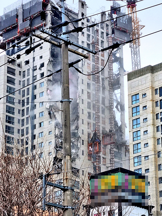 An apartment complex under construction suffers a collapse in Gwangju on Tuesday. One construction worker was injured by falling debris and a dozen vehicles were buried under fallen concrete chunks. [YONHAP]