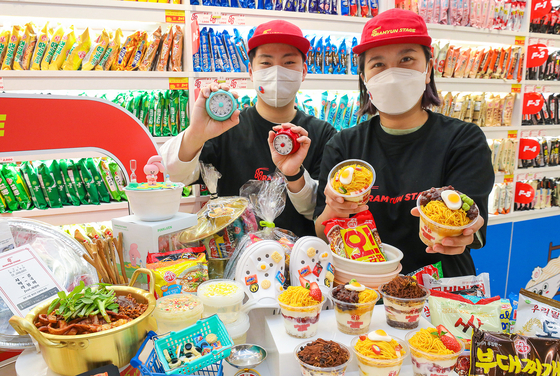 Models display ramyeon-related food and products sold at the 88 Ramyun Stage store at The Hyundai Seoul department store in Yeouido, western Seoul, on Wednesday. About 200 varieties of ramyeon will be sold at the location, along with tiramisu and fruit-topped yogurt that looks like a bowl of ramyeon. The store will temporarily be open until April 30. [HYUNDAI DEPARTMENT STORE GROUP] 