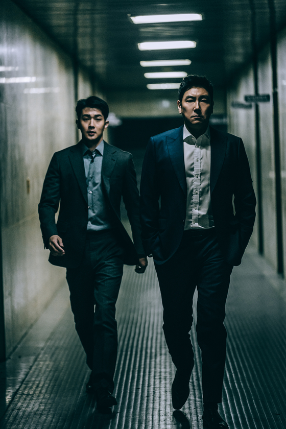 Young police detective Min-jae (played by actor Choi Woo-shik), left, is sent undercover to spy on a police detective Kang-yoon (played by Cho Jin-woong), right, who is rumored to be financially sponsored for his investigations by an unidentifiable source. [ACEMAKER MOVIEWORKS]