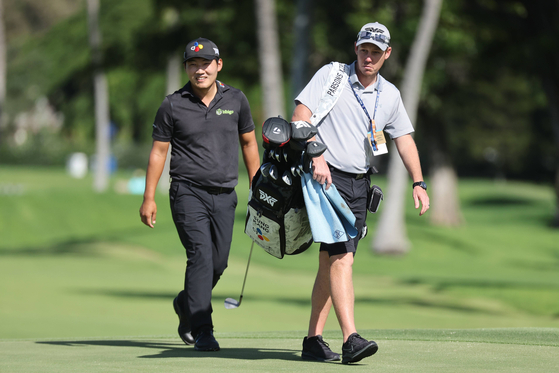 Kang Sung-hoon walks with his caddie during a practice round prior to the Sony Open in Hawaii at Waialae Country Club on Tuesday in Honolulu, Hawaii.  [AFP/YONHAP]