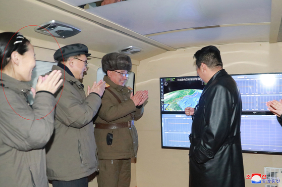 North Korean leader Kim Jong-un, right, observes a successful test-fire of a hypersonic glide vehicle on four monitors Tuesday, in a photo released by the state-run KCNA Wednesday. He is accompanied by his younger sister Kim Yo-jong, far left. [KCNA]