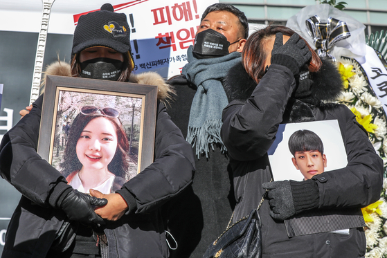 Parents whose children died after getting inoculated for Covid-19 hold a press conference while holding their children’s photos at the joint memorial altar in Cheonggye Square in Jongno District, central Seoul, on Thursday. They urged the government to come up with a special act to compensate victims of vaccines. [NEWS1]