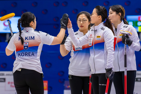 From left, Kim Kyeong-ae, Kim Seon-yeong, Kim Eun-jung and Kim Cho-hi cheer after winning 8-5 against Latvia on Dec.18 at the curling qualifying tournament for the 2022 Beijing Winter Olympics in the Elfstedenhal in Leeuwarden, the Netherlands. [WORLD CURLING FEDERATION] 