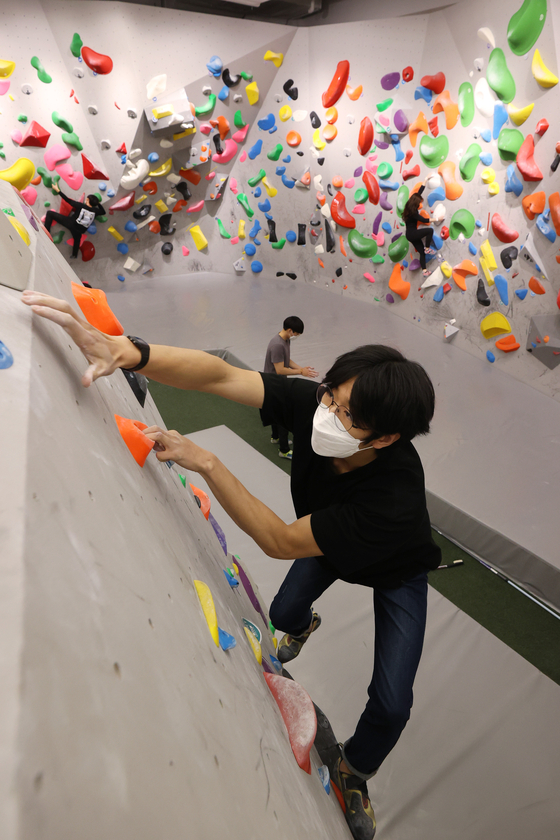  A customer tries a climbing wall at Peakers in the CGV Piccadilly 1958 in Jongno, Seoul, on Thursday. The multiplex, one of the oldest cinemas in Korea, turned one of its theaters into an indoor playground for adults. Movie theaters have been struggling over the last two years. In the first half of 2021 moviegoers dropped 38.2 percent year-on-year to 22 million. [YONHAP] 